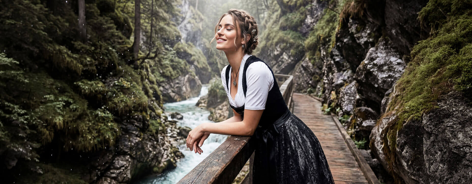 Dame mit hübschen Dirndl stehend auf einer Brücke in der Klamm