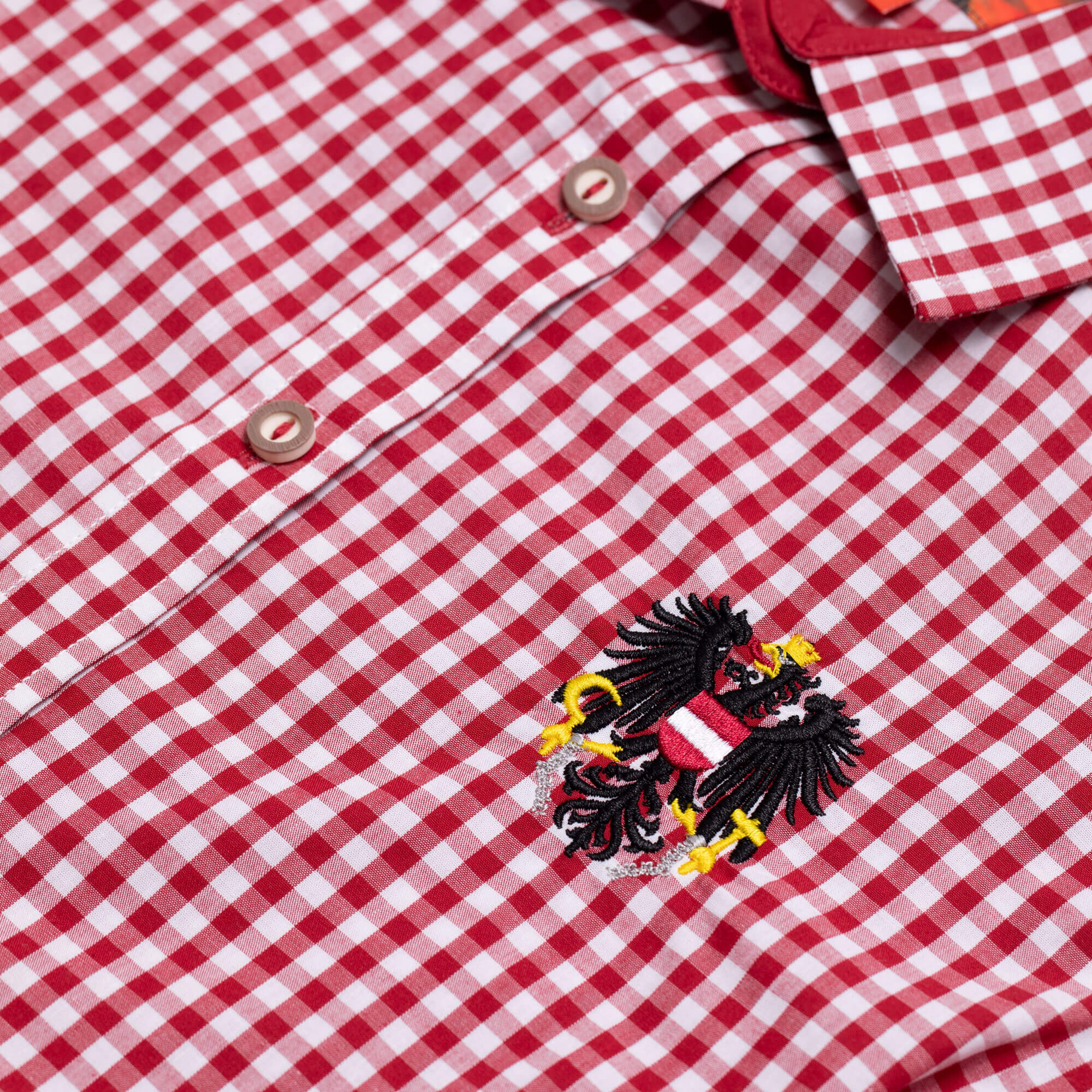 Detailansicht der Damen Bluse "Austria", mit kurzem Arm, in der Farbe Rot-Weiß Kariert, mit kleiner Adler Stickerei