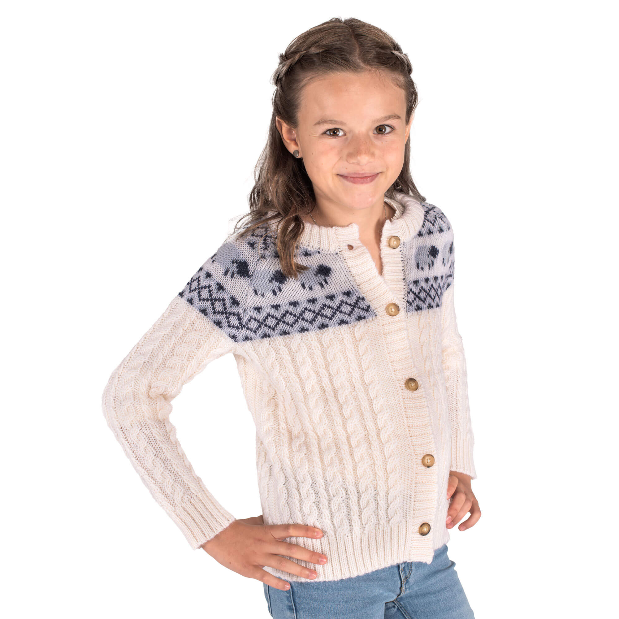 Kinder Model mit der Merino Kinder Strickjacke in der Farbe Weiß mit dezentem Schaf Strickmuster im Schulterberreich, mit Knopfverschluss