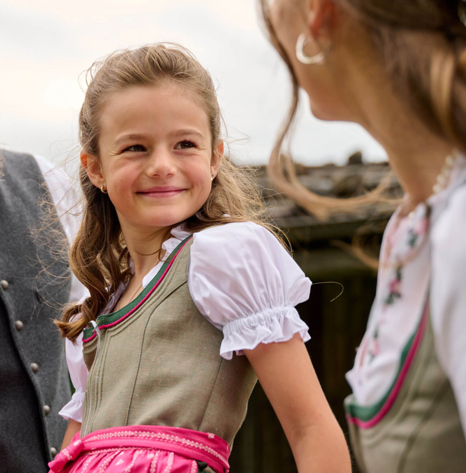 Detailansicht von Vorne des Kinder Dirndls "Irmi" in Hellolive-Pink, getragen vom Model