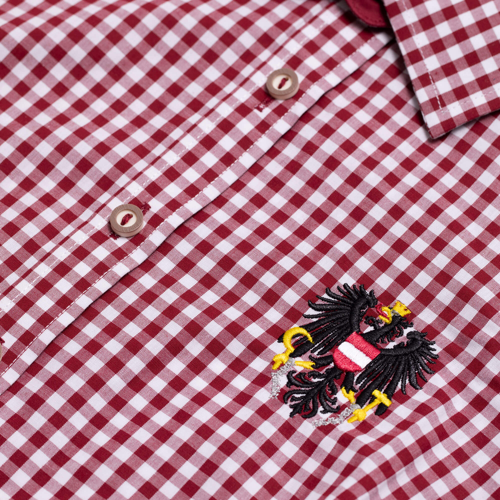 Detailansicht der Damen Bluse "Austria", mit kurzem Arm, in der Farbe Dunkelrot-Weiß Kariert, mit kleiner Adler Stickerei
