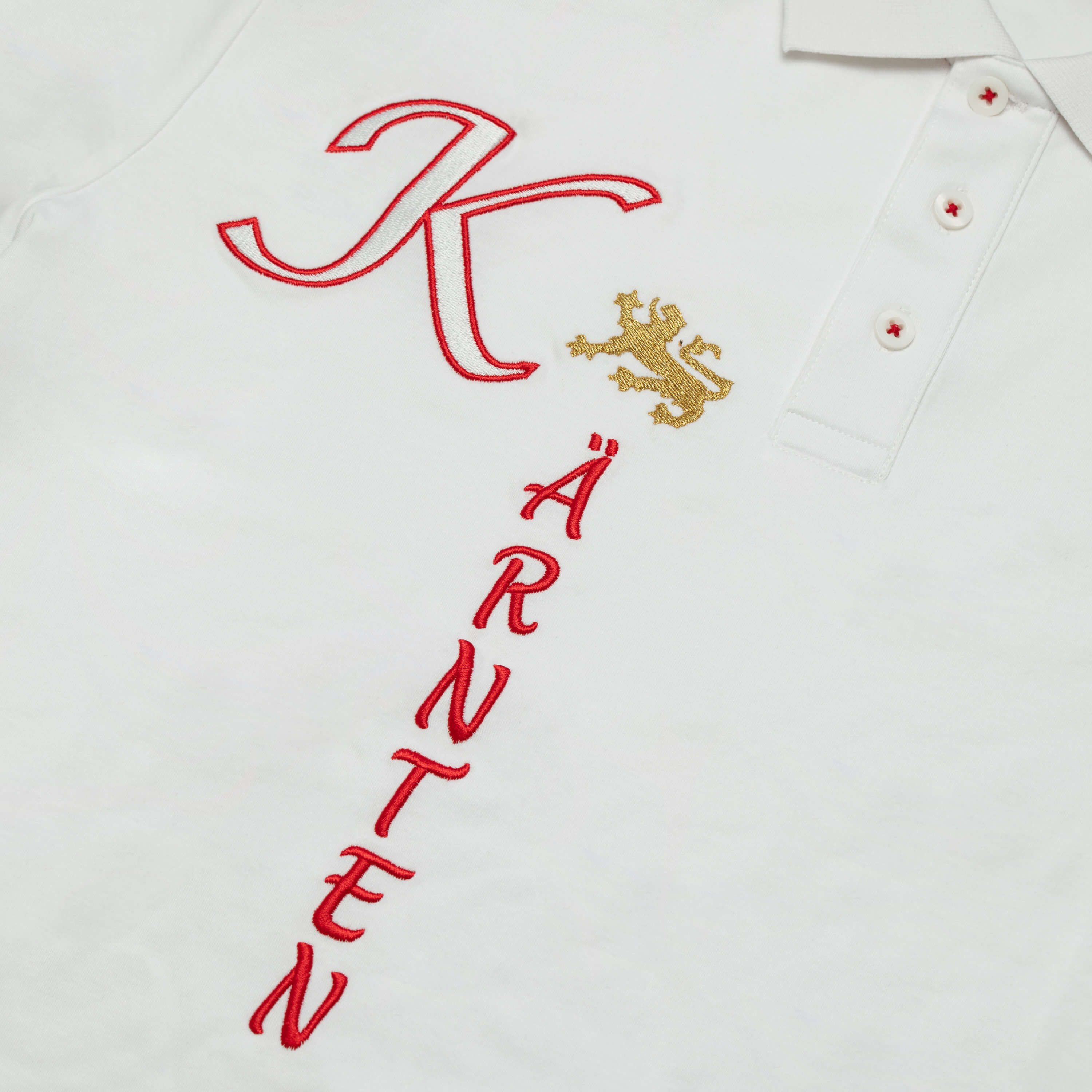 Detailansicht des Herren Polo "Kärnten", mit kurzem Arm, in der Farbe Weiß, mit Kärnten Schriftzug vorne
