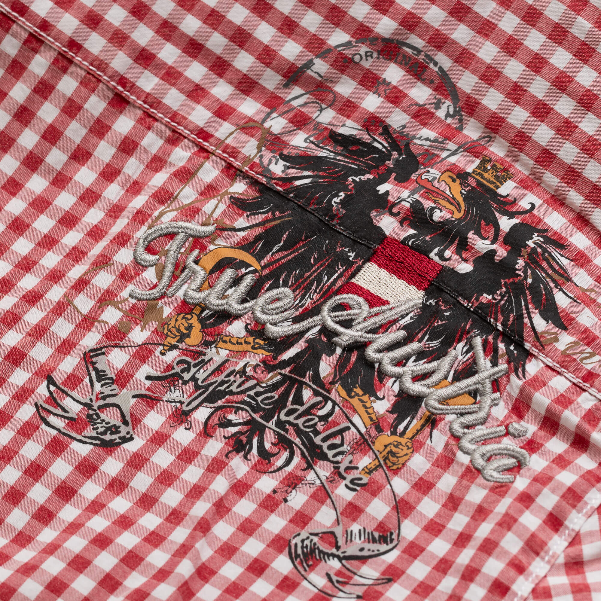 Detailansicht des Herren Hemd "Austria" in der Farbe Rot-Kariert, mit Schriftzug Stickerei hinten