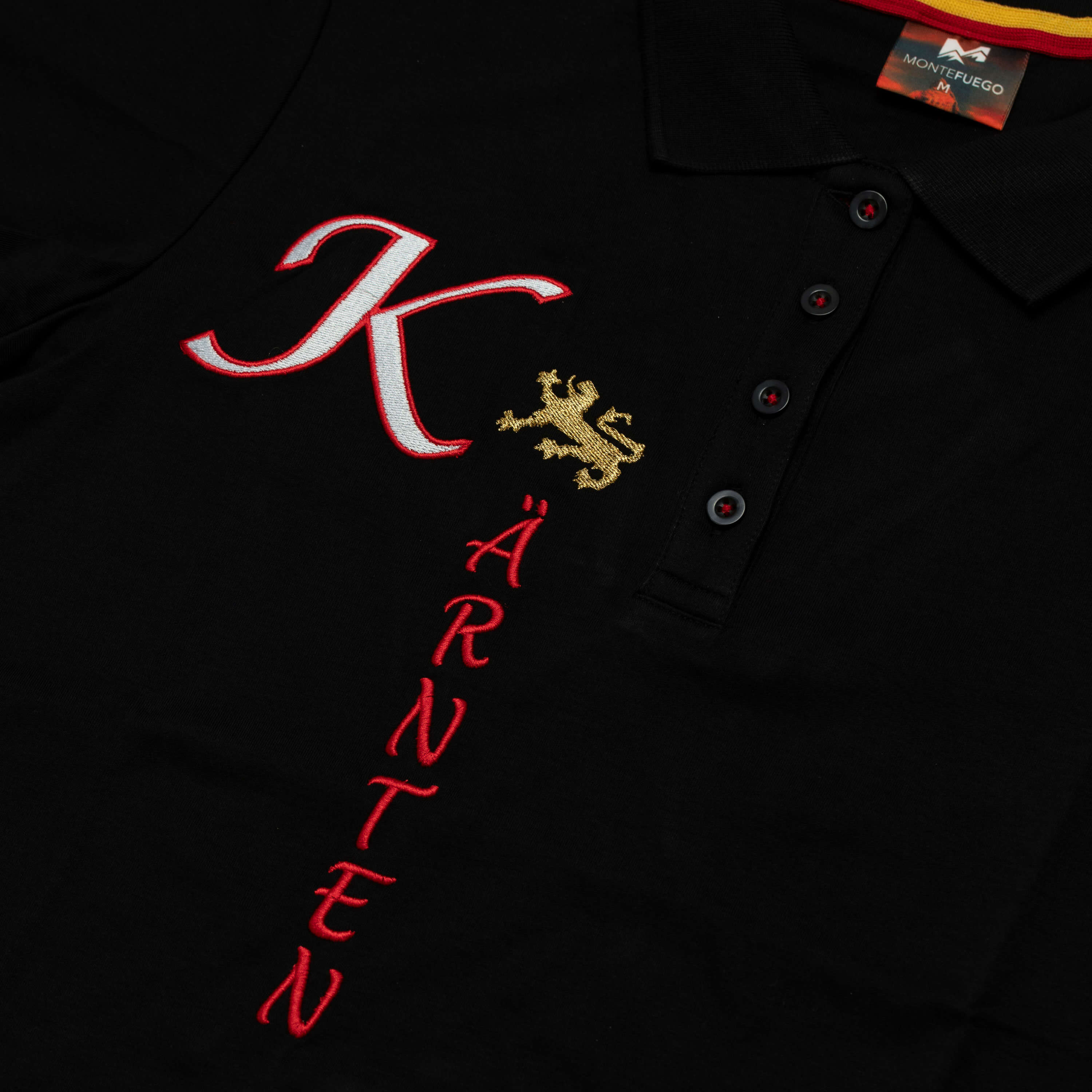 Detailansicht des Damen Polo "Kärnten", mit kurzem Arm, in der Farbe Schwarz, mit Kärnten Schriftzug vorne