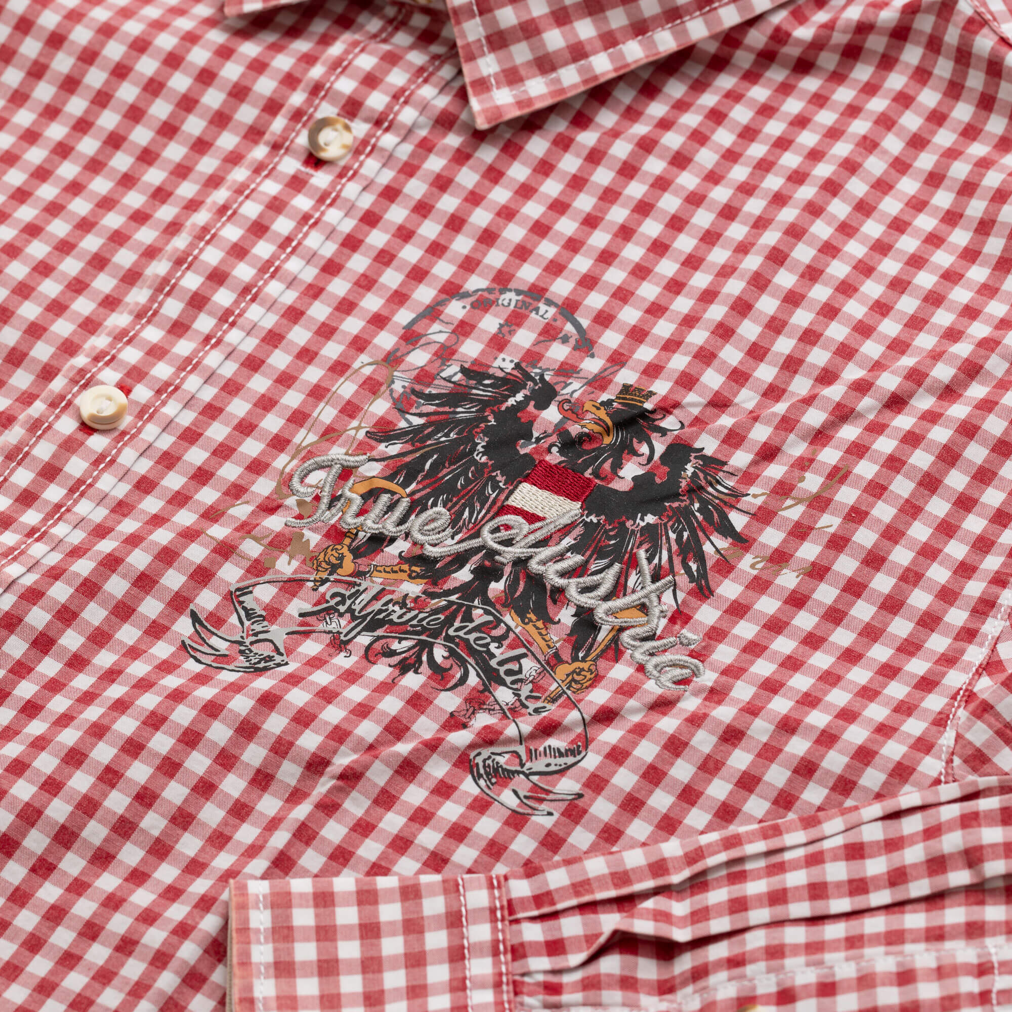Detailansicht des Herren Hemd "Austria" in der Farbe Rot-Kariert, mit Adler Druck vorne