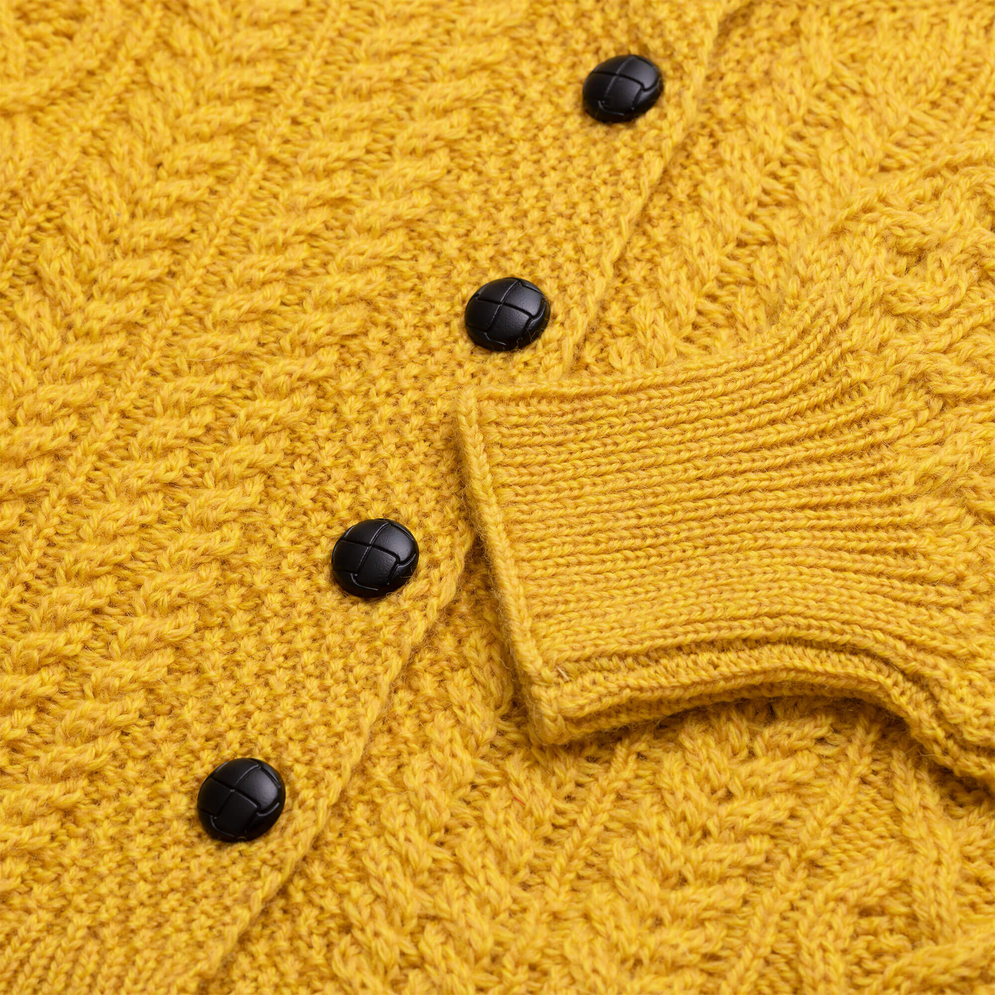 Detailansicht der Damen Strickjacke "Alma", mit langen, weiten Ärmeln, in der Farbe Curry, Ausschnitt Ärmelabschluss und Knopfleiste