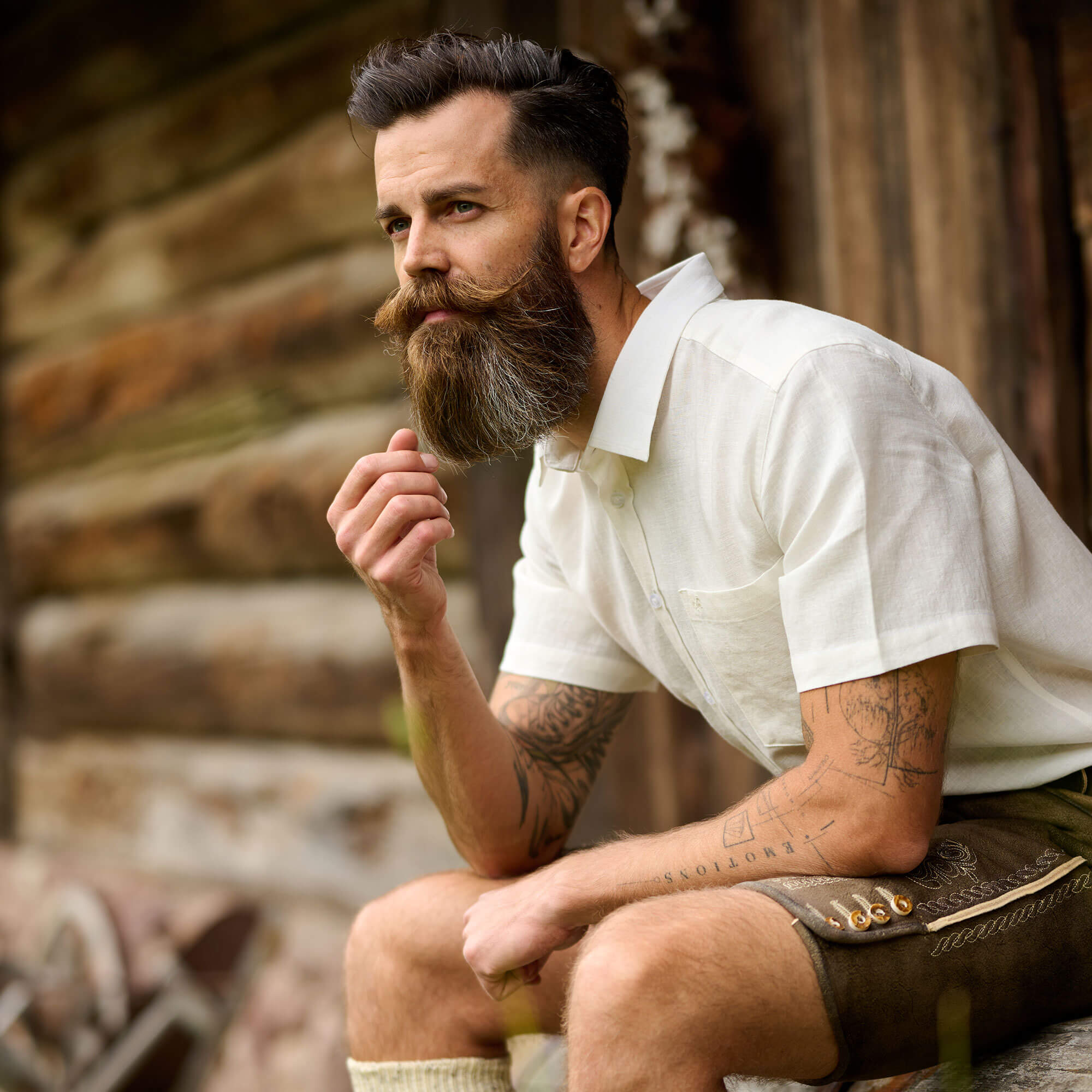 Junger Mann der Trachtenmode für Herren trägt (Lederhose mit Hemd)