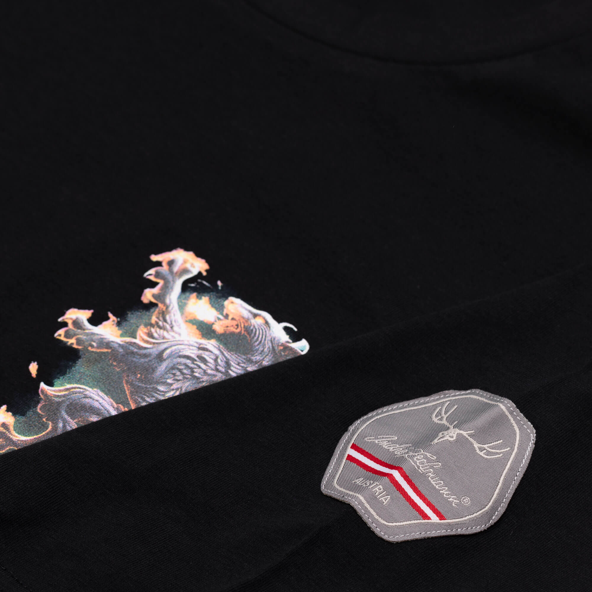Detailansicht des Herren T-Shirt "Steiermark", in der Farbe Schwarz, mit Patch am Ärmel