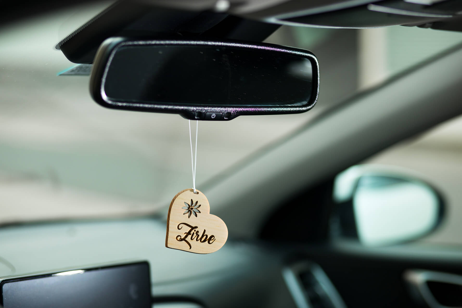 Ansicht des Autodufts aus Zirbe "Herz mit Schriftzug", hängend im Auto