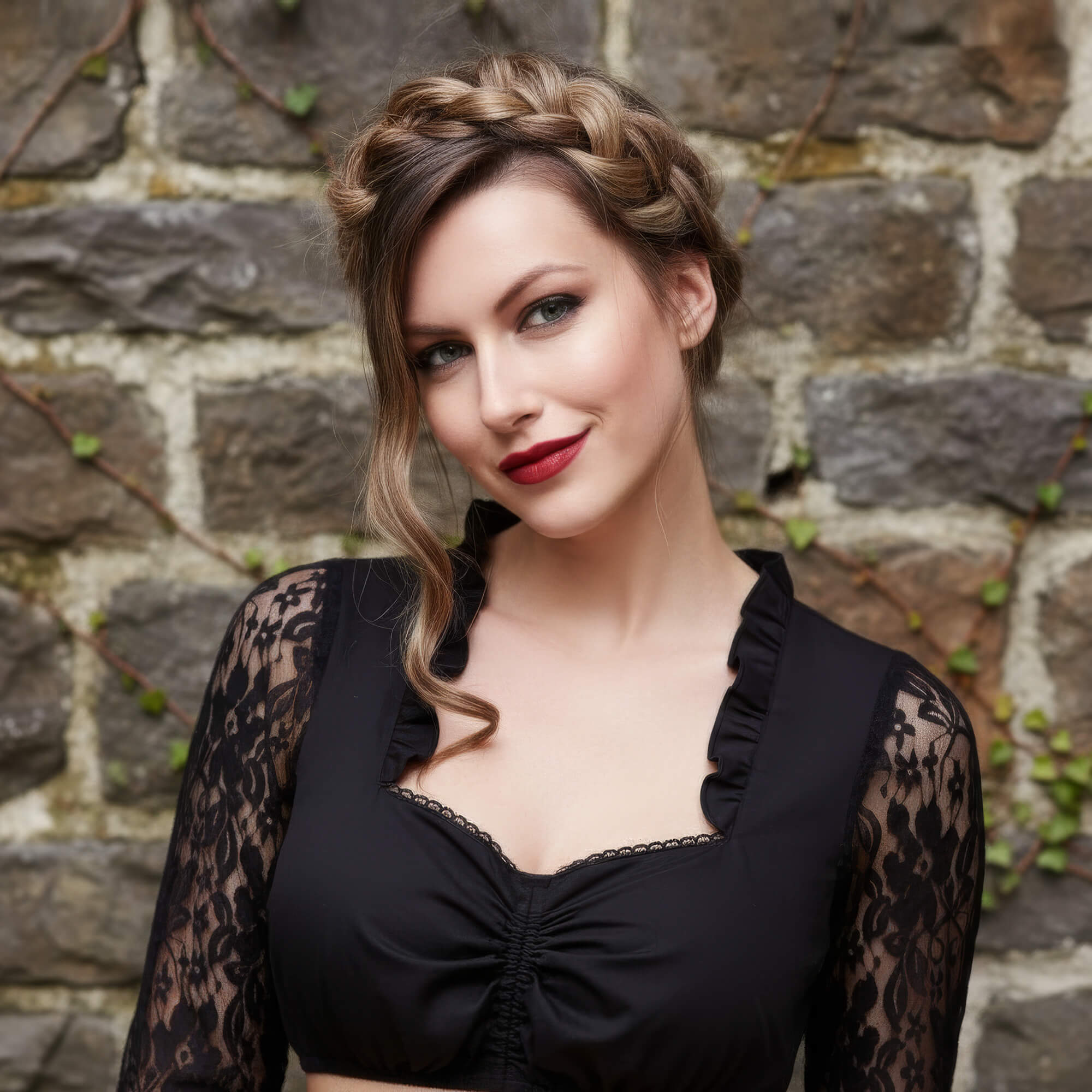 Frau mit elegantem langärmeligen Dirndlbluse mit Spitzen in der Farbe Schwarz